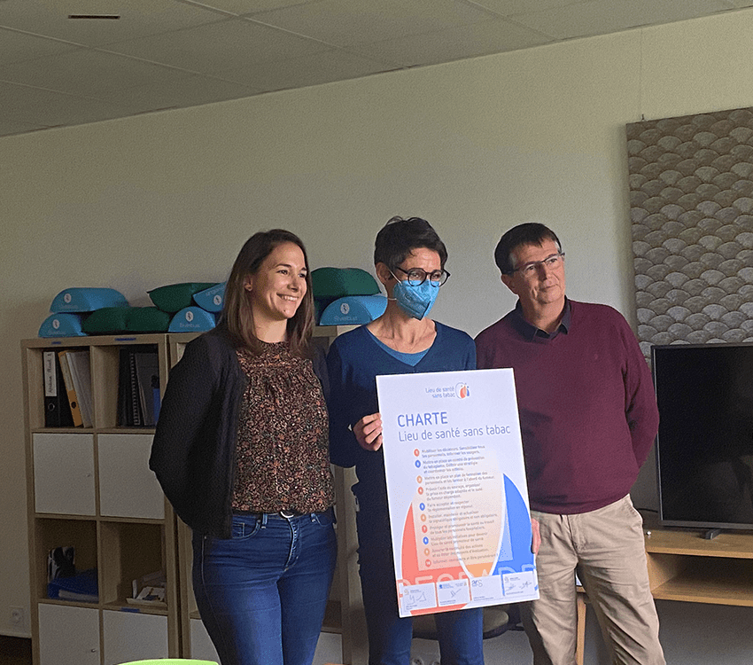 deux femmes et un homme debout souriant